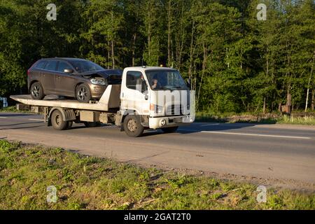 Un chariot de remorquage conduit une voiture après un accident. Transport de voiture sur une plate-forme de chargement. Le chargeur permet de retirer le véhicule de secours. Banque D'Images