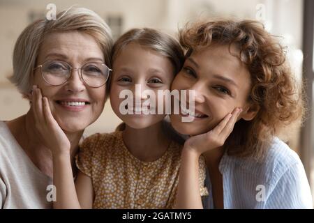 Portrait de tête heureux trois générations de femmes se posant ensemble Banque D'Images