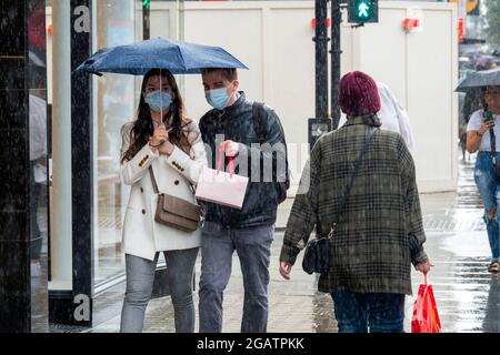 Pic shows: Le temps humide a frappé les acheteurs à Oxford Street le samedi après-midi alors que le juillet pluvieux a continué au tout dernier jour du mois 31.7.21 Banque D'Images