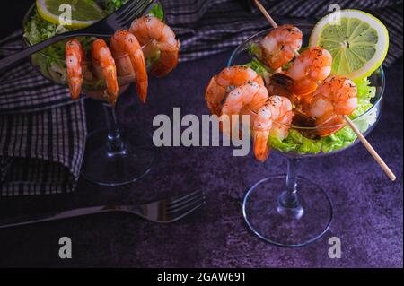 Entrée au cocktail de crevettes épicées servi dans un restaurant touristique tropical dans un verre décoré de crevettes avec une saupoudrière d'aneth, de citron, de laitue et d'autres Banque D'Images