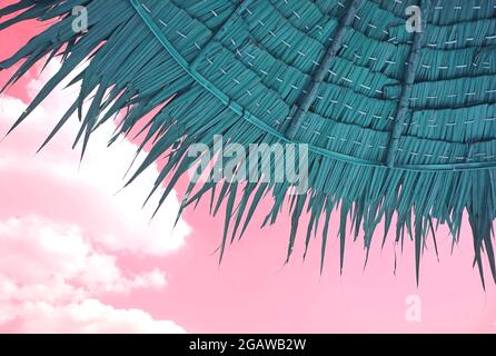 Style surréaliste Pop Art Sarcelle parasol de plage de chaume de couleur sur fond de ciel rose Banque D'Images