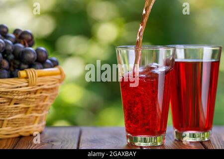 jus de raisin versé dans le verre sur la table dans le jardin Banque D'Images