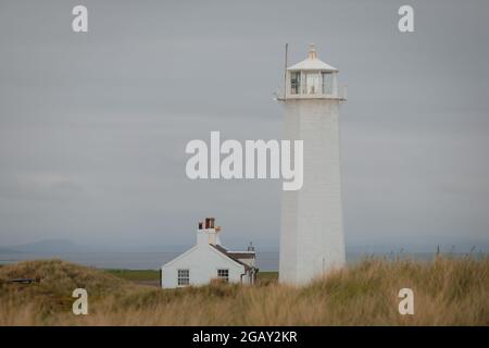 Le phare de Walney et le cottage sur l'île de Walney dans les prairies au bord de la mer d'Irlande Banque D'Images