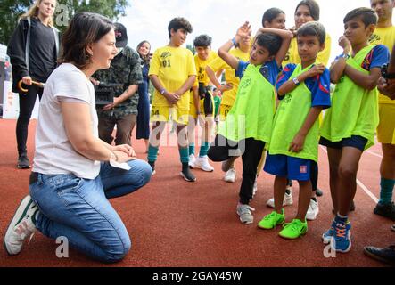 Potsdam, Allemagne. 1er août 2021. Annalena Baerbock (l), candidate à la chancelière et première candidate de Bündnis 90/Die Grünen, discute avec des enfants du 'Forster Löwen' et de l'équipe Blue lors du tournoi de football pour jeunes 're:start'. Le tournoi 're:start Street Soccer Championship' est organisé par la Brandenburg Sports Youth. L'objectif est d'amener les enfants et les jeunes à se déplacer à nouveau après la pandémie et d'inspirer les enfants d'un large éventail de familles à adopter le sport de club. Credit: Soeren Stache/dpa-Zentralbild/dpa/Alay Live News Banque D'Images