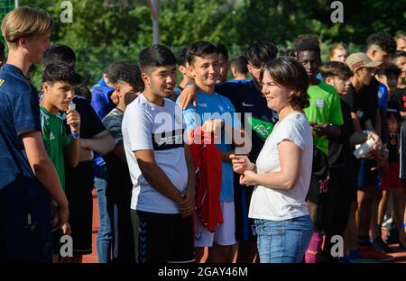 Potsdam, Allemagne. 1er août 2021. Annalena Baerbock, candidate à la chancelière et première candidate de Bündnis 90/Die Grünen, parle aux participants de différentes équipes lors du tournoi de football de la jeunesse 're:start'. Le tournoi 're:start Street Soccer Championship' est organisé par la Brandenburg Sports Youth. L'objectif est d'amener les enfants et les jeunes à se déplacer à nouveau après la pandémie et d'inspirer les enfants d'un large éventail de familles à adopter le sport de club. Credit: Soeren Stache/dpa-Zentralbild/dpa/Alay Live News Banque D'Images