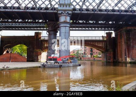 Barge flottante noire avec une grue Poclain TP 45 amarrée par la piste de remorquage du canal de Bridgewater à Castlefield, Manchester, nord-ouest de l'Angleterre, Royaume-Uni Banque D'Images