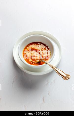 Sauce satay dans un bol blanc avec cuillère sur fond blanc – FOOPPIX BLANC Banque D'Images