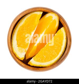 Tranches d'orange, dans un bol en bois. Des oranges coupées fraîches, des fruits mûrs et doux tranchés avec du jaune et de la chair de fruits juteuse. Trois coins. Banque D'Images