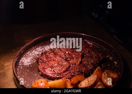 Steak de bœuf moyen-rare et grillé, équilibré, accompagné de citrouille rôtie et d'une salade d'herbes vertes dans un pub ou une taverne rustique Banque D'Images