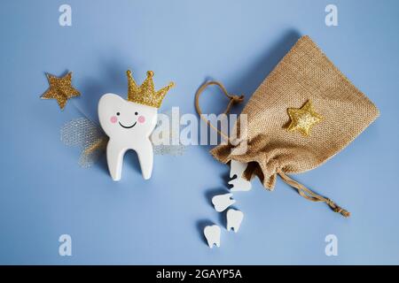 Journée nationale de la fête des Tooth. Fée dentaire pour enfants. Dent mignonne avec des ailes, une couronne et une baguette magique et un sac avec des dents. Banque D'Images