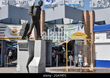 Un jeune garçon refroidit à un arc de pulvérisation de brume lorsque la température maximale dépasse 37 degrés à Slavyansk. Banque D'Images