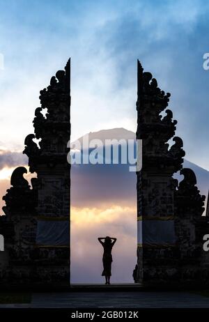 Une silhouette de femme admirant un coucher de soleil Banque D'Images
