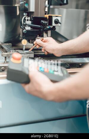 Employé en usine mettant l'outil dans une machine à poinçonner Banque D'Images