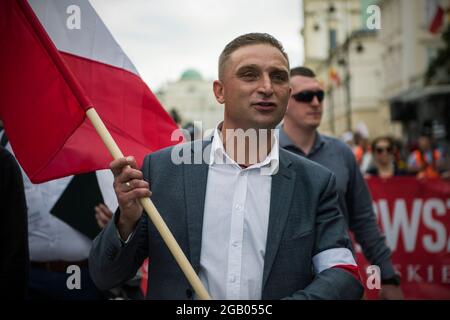 Varsovie, Pologne. 1er août 2021. Robert Bakiewicz, dirigeant du camp radical national (RNO), est vu arborer un drapeau polonais pendant le mois de mars.des milliers de personnes ont participé à une marche organisée par le camp radical national (RNO) et d'autres organisations nationalistes pour commémorer le 77e anniversaire du soulèvement de Varsovie (Powstanie Warszawskie). Crédit : SOPA Images Limited/Alamy Live News Banque D'Images