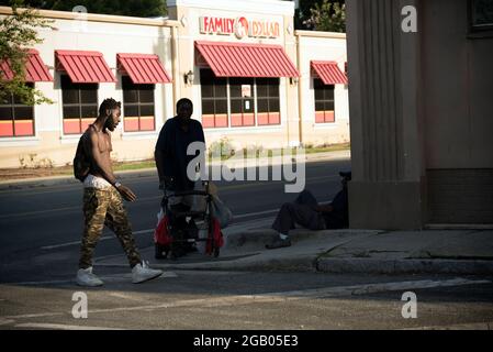 Tampa, Floride, États-Unis. 1er août 2021. Les hommes sans domicile passent le temps le long d'une rue de Tampa dans un quartier à faible revenu, où la toxicomanie et l'alcoolisme et les maladies mentales sont courantes. (Image de crédit : © Robin Rayne/ZUMA Press Wire) Banque D'Images