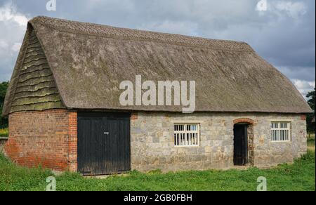 belle ancienne grange en pierre et en briques murées de chaume transformée en bureau de ferme et de stockage Banque D'Images