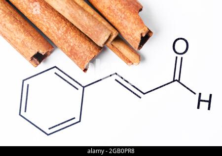 Cannelle aromatique et cinnamaldéhyde, structure chimique et formule. Composé organique qui donne à la cannelle sa saveur et son odeur. Banque D'Images