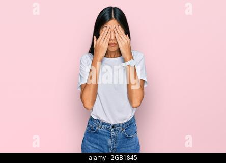 Belle jeune femme asiatique portant décontracté t t shirt blanc yeux de frottement pour la fatigue et les maux de tête, l'expression endormi et fatigué. Problème de vision Banque D'Images