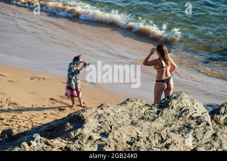 Salvador, Bahia, Brésil - 21 mai 2021: Fille faisant de sa mère l'art de l'auto-portrait à Praia do Porto da Barra à Salvador, Bahia. Banque D'Images