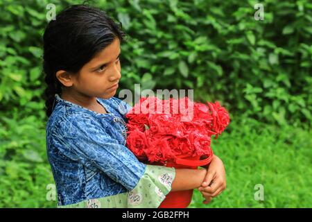 Dhaka, Bangladesh. 1er août 2021. Un enfant de la rue Sinthia Akter, âgée de 8 ans, vend des fleurs à l'Université de Dhaka, au Bangladesh. Crédit : SOPA Images Limited/Alamy Live News Banque D'Images