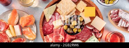 Panorama des antipasti italiens ou des tapas espagnols. Assiette gastronomique de viande froide et fromage, prise du dessus avec du vin. Une variété de hors-d'œuvre. Fête méditerranéenne Banque D'Images