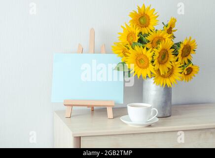 Carte papier vierge avec maquette espace copie bouquet de tournesols, une tasse de café. Sur fond blanc. Photo de haute qualité Banque D'Images