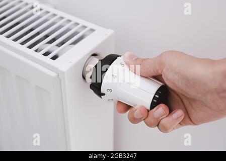 Bouton du radiateur de chauffage. Femme Réglage manuel de la température sur le radiateur de chauffage Banque D'Images