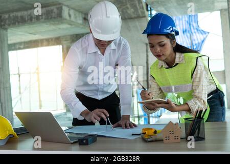 Groupe d'ingénieurs et d'architectures planifiant et vérifiant la conception intérieure des bâtiments dans le concept de travail de chantier, d'équipe et de travail d'équipe Banque D'Images