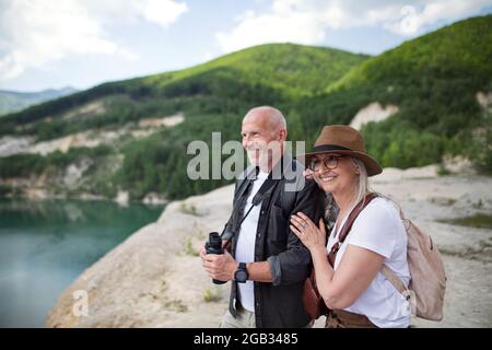 Couple de personnes âgées heureux sur une randonnée pendant les vacances d'été, en regardant le paysage. Banque D'Images