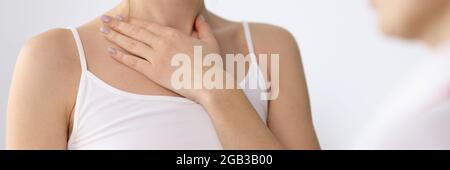 Main de femme montrant une plaie au cou lors d'un rendez-vous avec un médecin en gros plan Banque D'Images