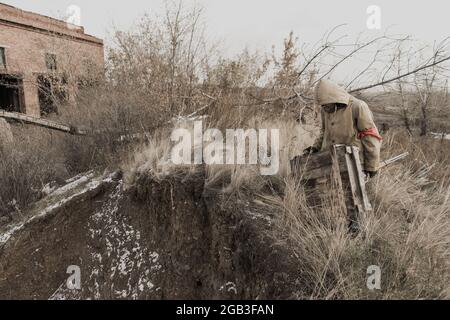 garçon errant. garçon avec une arme. garçon va dans un bâtiment abandonné. garçon se tient devant un bâtiment. Après l'apocalypse. Homme voyageant à pied dans un post- Banque D'Images