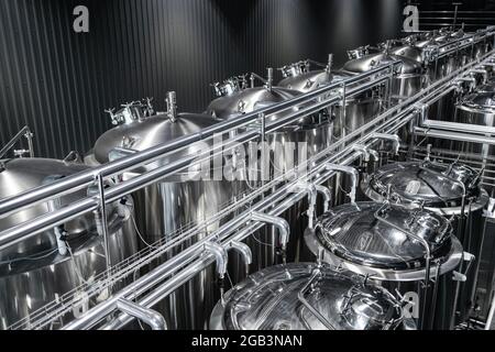 Intérieur industriel de la brasserie artisanale moderne avec réservoirs à bière cylindriques en métal chromé Banque D'Images