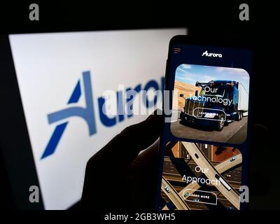 Personne tenant un téléphone cellulaire avec la page Web de la compagnie de véhicules autopilotant Aurora innovation Inc. À l'écran avec logo. Concentrez-vous sur le centre de l'écran du téléphone. Banque D'Images