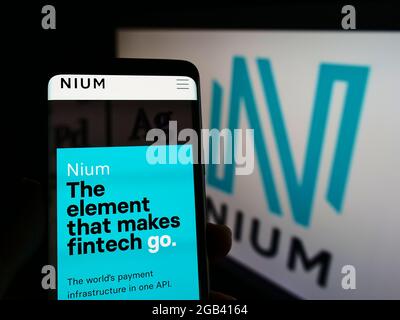 Personne tenant un smartphone avec le site Web de la société de paiement singapourienne NIUM Pte. Ltd. À l'écran devant le logo. Concentrez-vous sur le centre de l'écran du téléphone. Banque D'Images