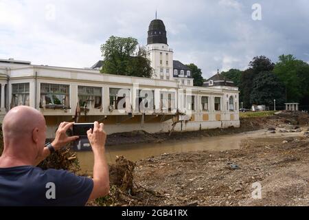 02 août 2021, Rhénanie-Palatinat, Bad Neuenahr-Ahrweiler : un homme prend une photo du Kurhaus endommagé par les inondations avec son téléphone portable. Deux semaines et demie après la catastrophe des inondations, le travail de nettoyage est en plein essor. Photo: Thomas Frey/dpa Banque D'Images