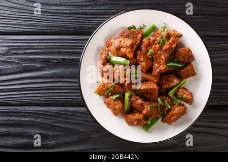 Cuisine éthiopienne viande de bœuf frite Tibs dans une sauce épicée aux légumes dans une assiette sur la table. Vue horizontale du dessus Banque D'Images