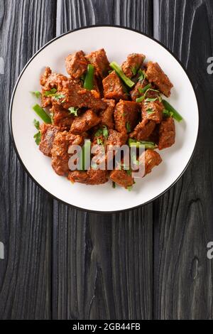 Ragoût de bœuf Tibs traditionnel et authentique nourriture éthiopienne dans l'assiette sur la table. Vue verticale du dessus Banque D'Images