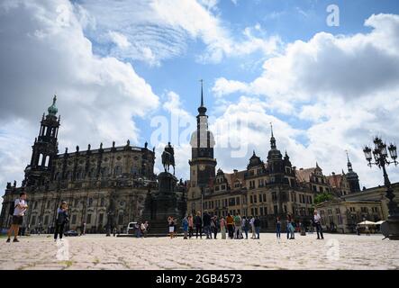 02 août 2021, Saxe, Dresde: Les touristes se tiennent sur la Theaterplatz en face de la Hofkirche (l-r), de la statue équestre du roi Johann, du Hausmannsturm, de la Residenzschloss et de la Schinkelwache. Photo: Robert Michael/dpa-Zentralbild/dpa Banque D'Images