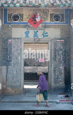 Portrait d'une vieille dame marchant dans un village chinois Banque D'Images
