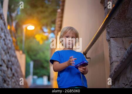 Heureux beaux enfants, garçons, jouer sur pierre escalier casechild, enfant, tout-petit, appareil photo, petit, escaliers, escalier, vieux, pierre, vieille ville, fren dans ancien à Banque D'Images