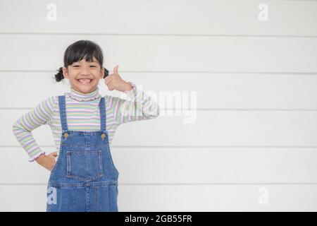 Portrait de petite fille asiatique mignonne avec son bosse vers le haut, concept de publicité, petite adolescence asiatique s'affine avec le fond blanc et l'espace Banque D'Images