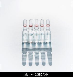Ampoules en verre avec médicament, vaccin pour injections médicales et cosmétiques composition à partir d'ampoules à ombre Banque D'Images