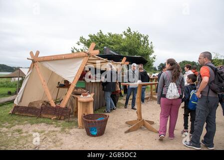 Les acteurs de la vie réelle agissent comme des villageois vêtus de vêtements viking d'âge moyen qui font et vendent des repas traditionnels dans le village de Viking Haithabu. Pris à Busdo Banque D'Images
