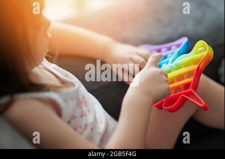 Jouet en plastique popit brillant dans les mains d'enfant vue rapprochée Banque D'Images