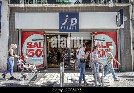 Les amateurs de shopping se prominent devant le JD Sports Store de Donechall place, Belfast. Banque D'Images