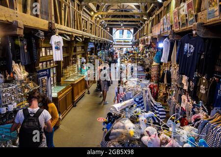 Les touristes vont faire du shopping dans le vieux marché d'Etretat, France, un marché couvert construit en 1927 pour les étals de poissons, qui abrite maintenant des boutiques de cadeaux et des magasins de plage Banque D'Images