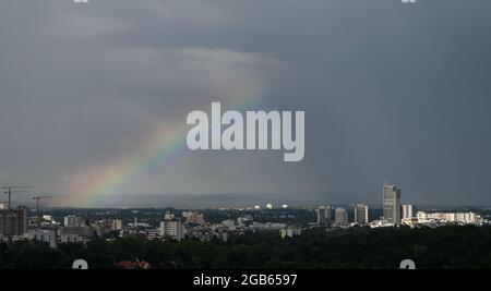 02 août 2021, Hessen, Francfort-sur-le-main : un arc-en-ciel est vu dans l'après-midi après le passage d'une zone de pluie derrière Offenbach-Kaiserlei (l) et le centre-ville d'Offenbach am main. Photo: Arne Dedert/dpa Banque D'Images