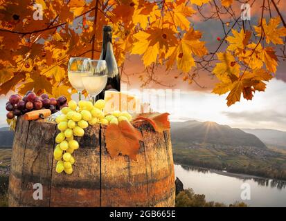 Coucher de soleil d'automne sur la vallée de Wachau avec une bouteille de vin sur le baril contre le village de Spitz près du Danube en Autriche Banque D'Images