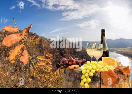 Bouteille de vin sur baril contre le château de Duernstein près du Danube pendant l'automne à Wachau, Autriche Banque D'Images