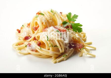Tas de délicieux spaghetti au bacon servi avec du parmesan et du persil sur fond blanc Banque D'Images